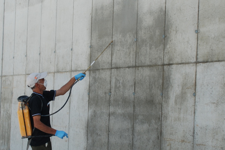 Spray application of Vetrofluid waterproofing on a concrete wall