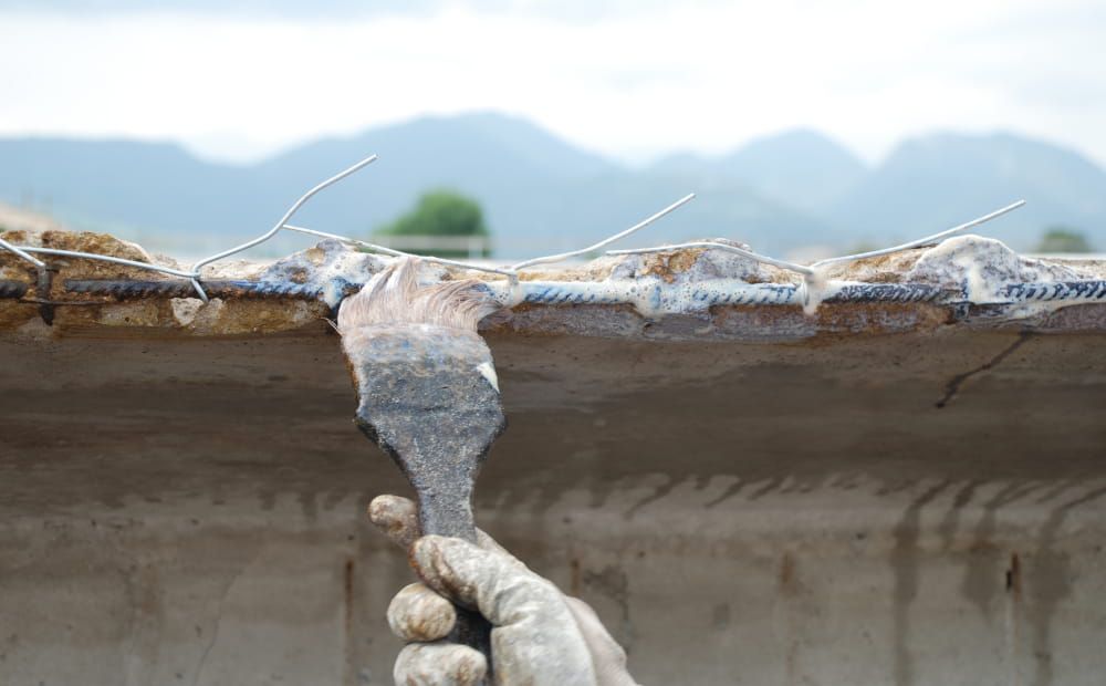 Brushing Rust Buster rust converter onto rebar before repair